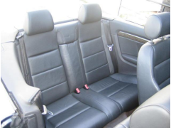 Audi with a concealed anchorage between upper sections of the seat backrest