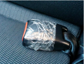 A seatbelt bucker coming apart that has been taped up