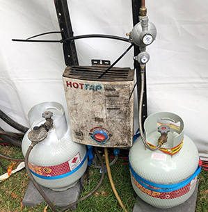 Two cylinders placed next to a hot water service, which is an ignition source. The ignition source is within the exclusion zone of 1500mm. This requires the cylinders or the hot water service to be moved.